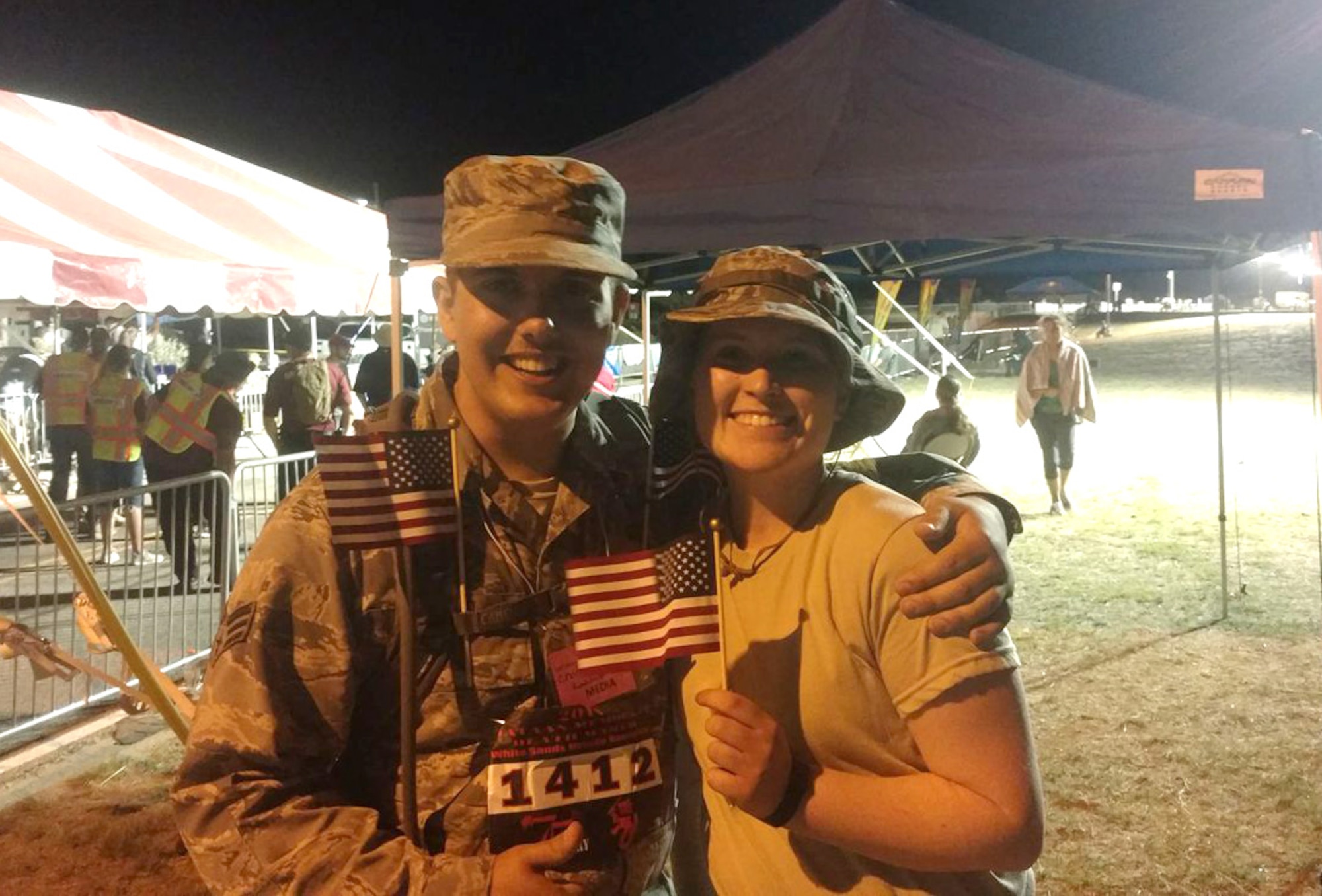 Senior Airman Chandler Baker and Airman Lexi Crawford, 377th Air Base Wing's Public Affairs Office, celebrate successfully completing the Bataan Memorial Death March to pose for a photo. The two participated in a 26-mile march through the high desert terrain of the White Sands Missile Range, N.M. The memorial march is conducted in honor of the heroic service members who defended the Philippine Islands during World War II, sacrificing their freedom, health, and, in many cases, their very lives. (Courtesy Photo)