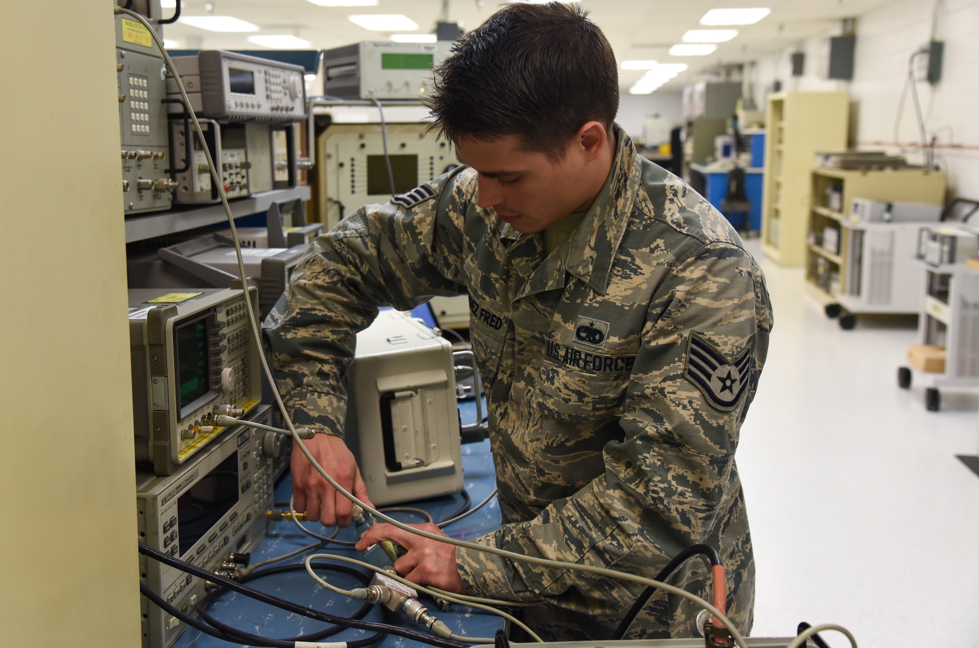 Staff Sgt. Edel Melendez Fred, 60th Maintenance Squadron precision measurement equipment laboratory technician, verifies configuration for transponder testing at Travis Air Force Base, Calif., March, 13, 2017. The PMEL shop ensures test equipment meets required standards. (U.S. Air Force photo by Senior Airman Sam Salopek) (This image was blurred for security purposes)