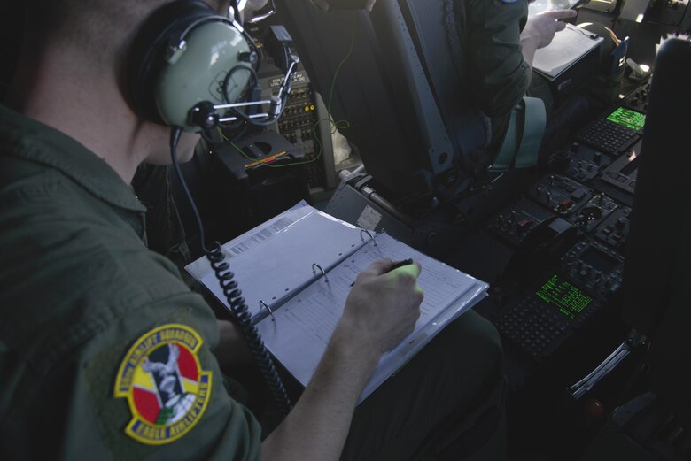 Staff Sgt. Christopher Hofer, 36th Airlift Squadron loadmaster, fills out a flight record form during the first Yokota C-130J Super Hercules training sortie over the skies of Japan March 20, 2017. The form allows the aircrew to document any discrepancies discovered by themselves or maintenance personnel. (U.S. Air Force photo by Staff Sgt. David Owsianka)