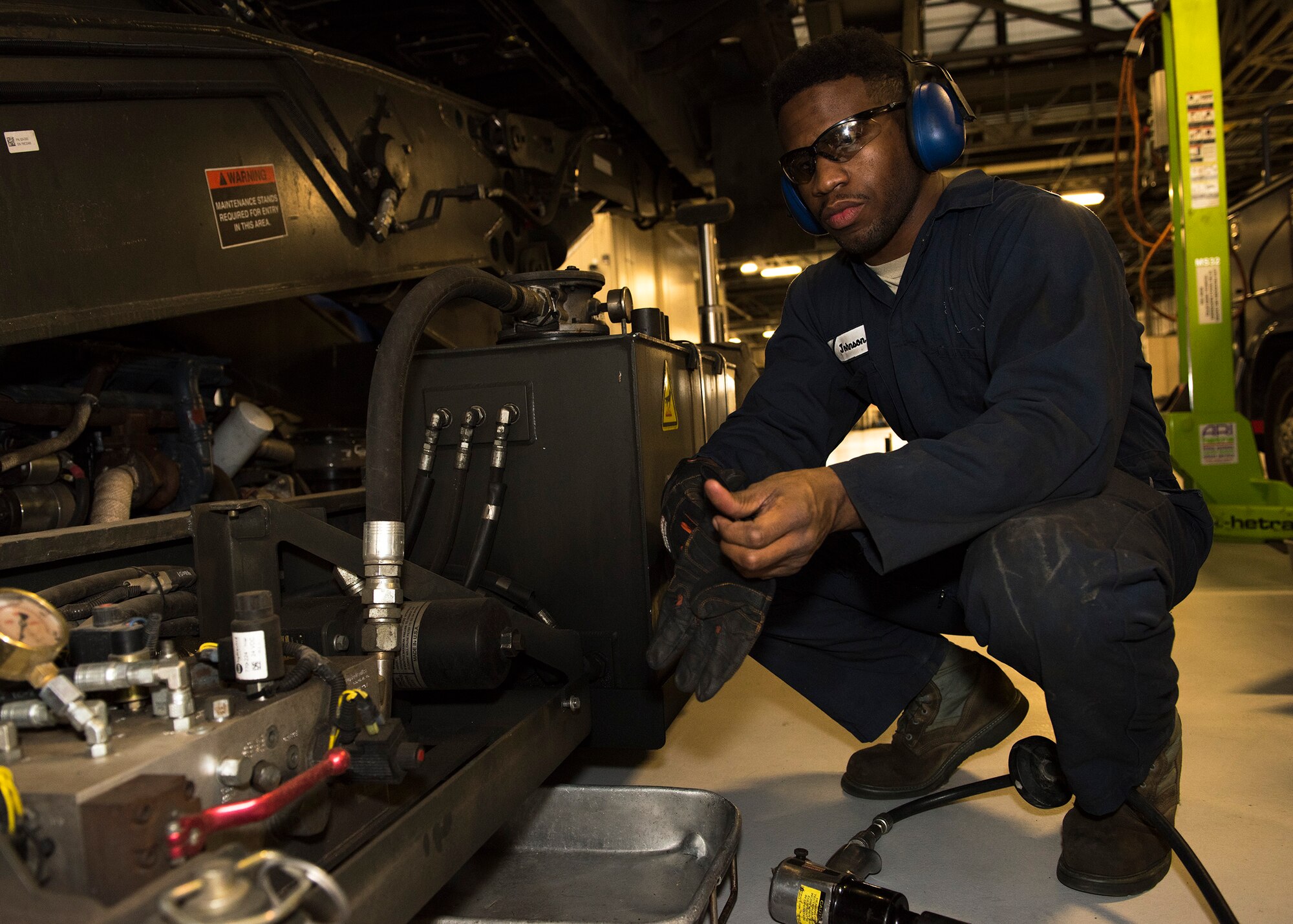 Senior Airman Brandon Johnson, 92nd Logistic Readiness Squadron Vehicle Maintenance journeyman, pauses working on a heavy aircraft loading vehicle March 20, 2017, at Fairchild Air Force Base, Wash. Johnson is a four-time team member of the United States Air Force wrestling team. (U.S. Air Force photo/Airman 1st Class Ryan Lackey)