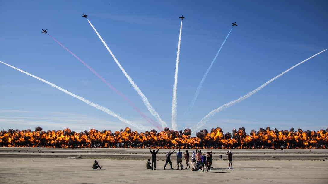 The Patriots Jet Team performs aerial acrobatics as pyrotechnics provided by the Tora Bomb Squad of the Commemorative Air Force explode, forming a "Wall Of Fire" during the 2017 Yuma Airshow at Marine Corps Air Station Yuma, Ariz., Saturday, March 18, 2017. The airshow served as an opportunity for MCAS Yuma to thank the local community for their continued support.