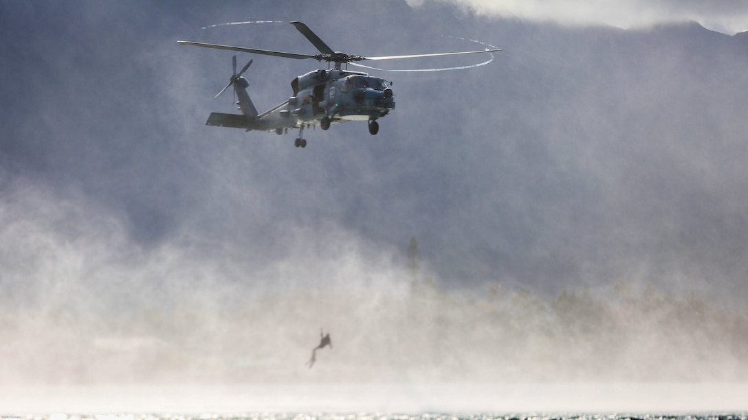 A search and rescue swimmer with Helicopter Maritime Strike Squadron 37 is lowered from a MH-60R helicopter during a search and rescue exercise off the shores of Marine Corps Base Hawaii on March 15, 2017. The Sailors conducted the exercise to better prepare for future deployments. 