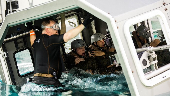 Marines with Special Purpose Marine Air-Ground Task Force - Southern Command assume brace positions as the Modular Amphibious Egress Trainer begins to submerge during Underwater Egress Training at the Water Survival Training Facility on Marine Corps Base Camp Lejeune, North Carolina, March 8, 2017. The purpose of the training is to teach Marines lifesaving skills in the event of an aircraft mishap in the water. 
