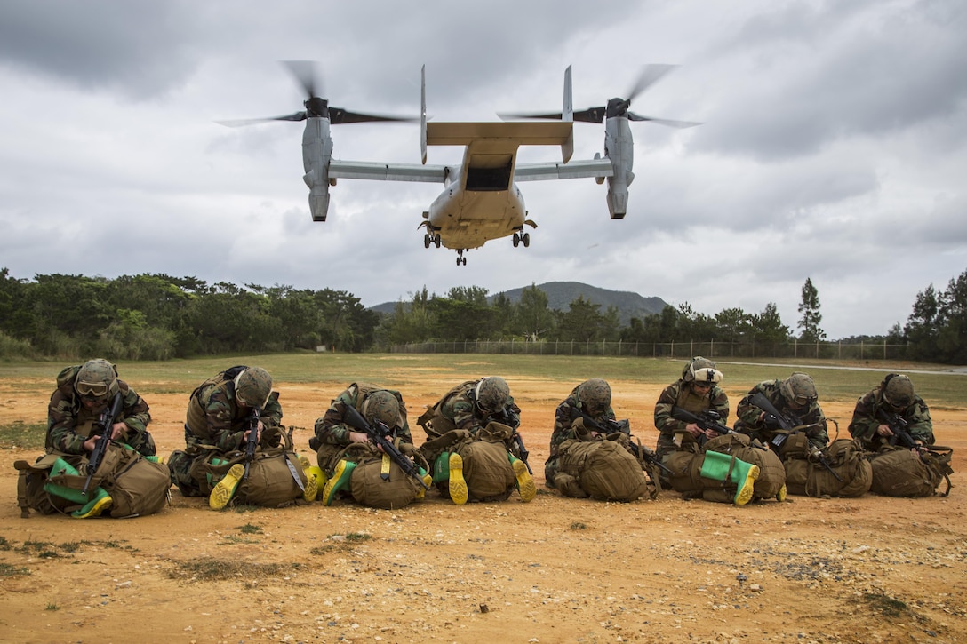 Marines assigned to the 3rd Marine Division's Chemical, Biological, Radiological and Nuclear Platoon protect themselves from debris as an MV-22 Osprey lands at Landing Zone Dodo, Camp Hansen, Okinawa, Japan, March 21, 2017. Marine Corps photo by Lance Cpl. Jesus McCloud