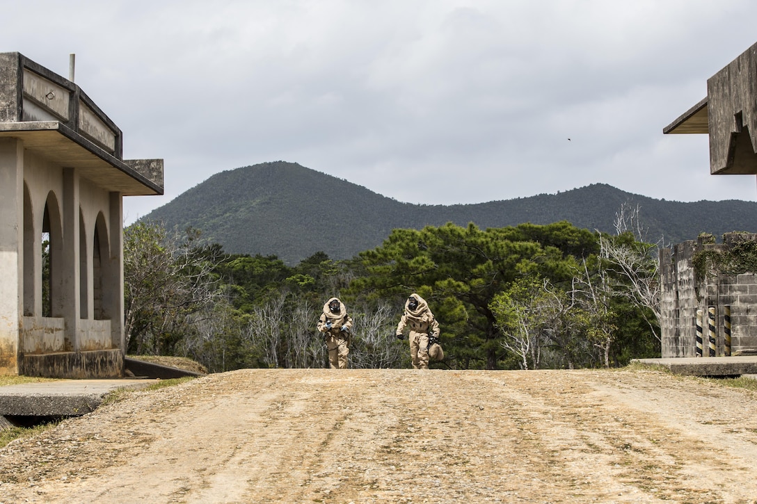 Marine Corps Cpl. James Dietrich, right, and Lance Cpl. Nickolas Giffen head toward the simulated “hot zone” in modified Level B suits on Combat Town, Okinawa, Japan, March 21, 2017. Dietrich is the sampling team leader and Giffen is a ampling team member with the 3rd Marine Division's Chemical, Biological, Radiological and Nuclear Platoon. Marine Corps photo by Lance Cpl. Jesus McCloud