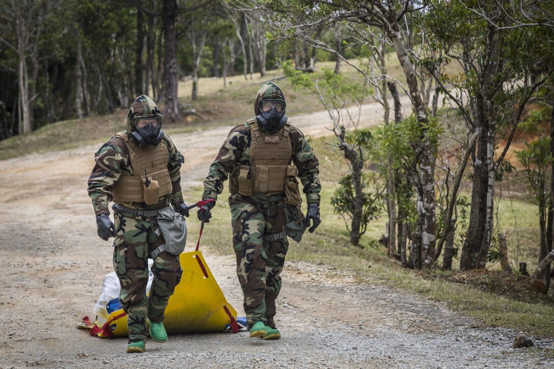 Marine Corps Cpls. William Pearson, left, and Carlos Flores walk back to the “cold zone” with their contaminated gear properly contained during a training event at Combat Town, Okinawa, Japan, March 21, 2017. Pearson and Flores are with the 3rd Marine Division's Chemical, Biological, Radiological and Nuclear Platoon. Marine Corps photo by Lance Cpl.  Jesus McCloud