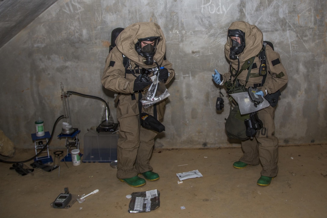 Marine Corps Cpl. Joshua Hatfield, left, and Lance Cpl. Mellisa Leathery collect simulated biological contamination gathered during a handheld assay in Combat Town, Okinawa, Japan, March 21, 2017. Hatfield is the recon team leader and Leathery is a recon team member with the 3rd Marine Division's Chemical, Biological, Radiological and Nuclear Platoon. Marine Corps photo by  Combat Camera Lance Cpl. Jesus McCloud