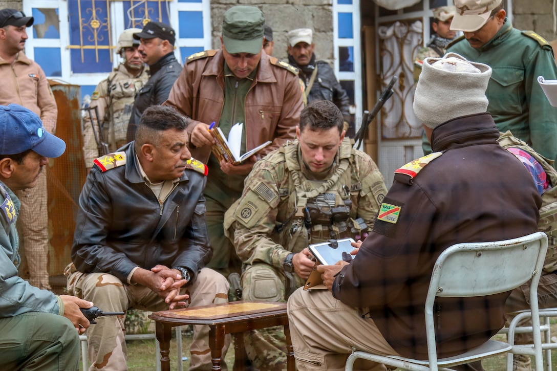 U.S. Army Capt. Mark G. Zwirgzdas, deployed in support of Combined Joint Task Force-Operation Inherent Resolve, assigned to 2nd Brigade Combat Team, 82nd Airborne Division, discusses operations during the offensive to liberate West Mosul from ISIS with 9th Iraqi Army Division leaders near Al Tarab, Iraq, March 19, 2017. The 2nd BCT, 82nd Abn, Div., enables their Iraqi security forces partners through the advise and assist mission, contributing planning, intelligence collection and analysis, force protection, and precision fires to achieve the military defeat of ISIS. CJTF-OIR is the global Coalition to defeat ISIS in Iraq and Syria. (U.S. Army photo by Staff Sgt. Jason Hull)