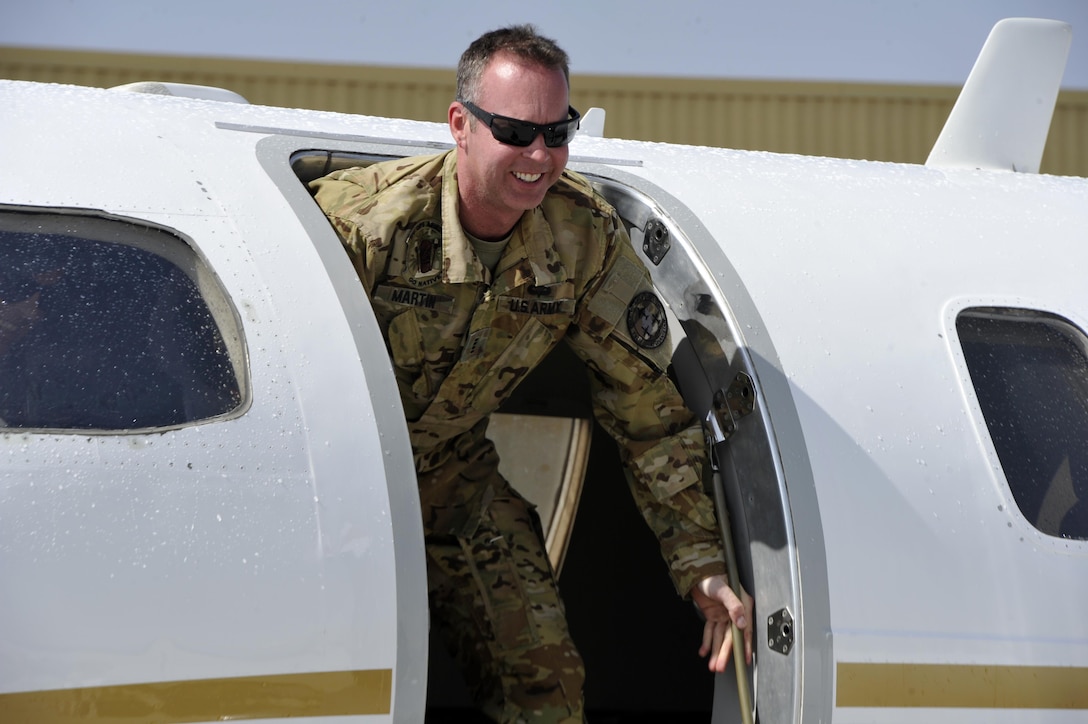 BAGRAM AIRFIELD, Afghanistan (Mar. 17, 2017) - Chief Warrant Officer 4 Joshua Wade Martin exits his C-26 Metrolina aircraft moments after landing here for his final military flight.  Martin is a 28-year veteran of the Arkansas Army National Guard who will redeploy soon and retire from military service this summer.  His team greeted his arrival for his last military flight with the traditional aviation water salute.  Photo by Bob Harrison, U.S. Forces Afghanistan Public Affairs.