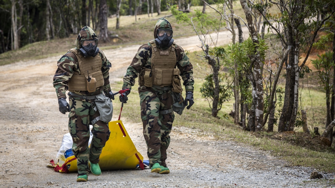 U.S. Marine Corps Cpl. William Pearson, Decontamination Team Member, left, and Cpl. Carlos Flores, Decontamination Team Leader, with Chemical, Biological, Radiological and Nuclear Platoon, G-3, 3d Marine Division, walk back to the “cold zone” with all contaminated gear properly contained at Combat Town, Okinawa, Japan, March 21, 2017. The CBRN Platoon conducts response drills to enhance the commander’s capabilities by exercising the operability and efficiency of the consequence management set within the 3d Marine Division CBRN response element.