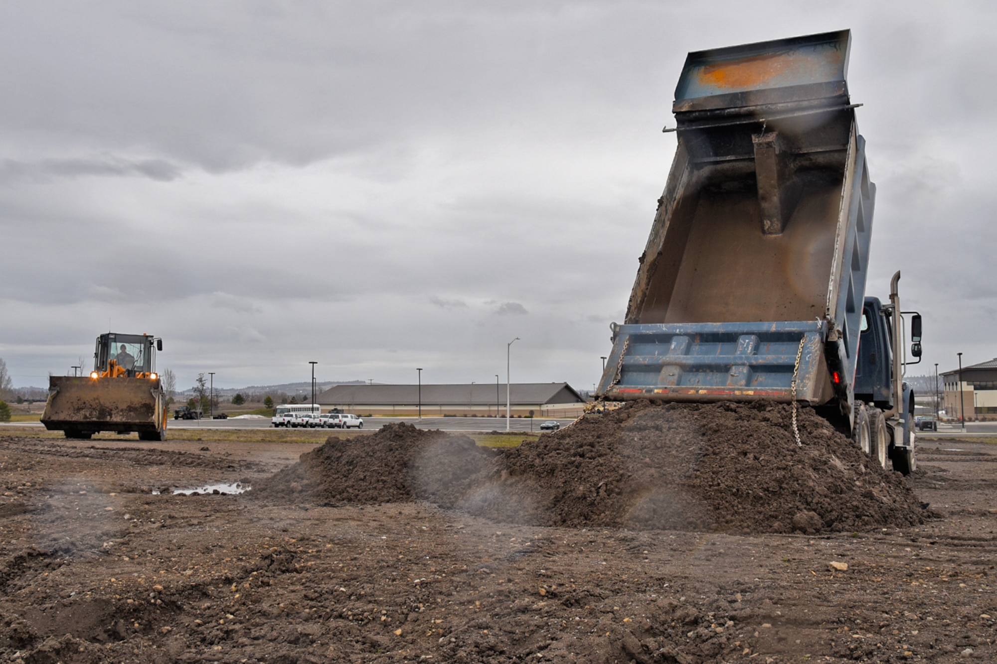 Airman 1st Class Manuel Rivera Matos and Staff Sgt. Steven Lowe, 92nd Civil Engineer Squadron pavement and construction technicians, use the loader and dump truck to move dirt Mar. 15, 2017, at Fairchild Air Force Base, Washington. The 92nd CES pavement and construction Airmen and civilians are often referred to as “Dirt Boyz” for their constant interaction with more than 100 pieces of filthy heavy construction equipment and hand tools used to repair Fairchild’s roads, airfield, fences and drainage systems. (U.S. Air Force photo/Senior Airman Mackenzie Richardson) 