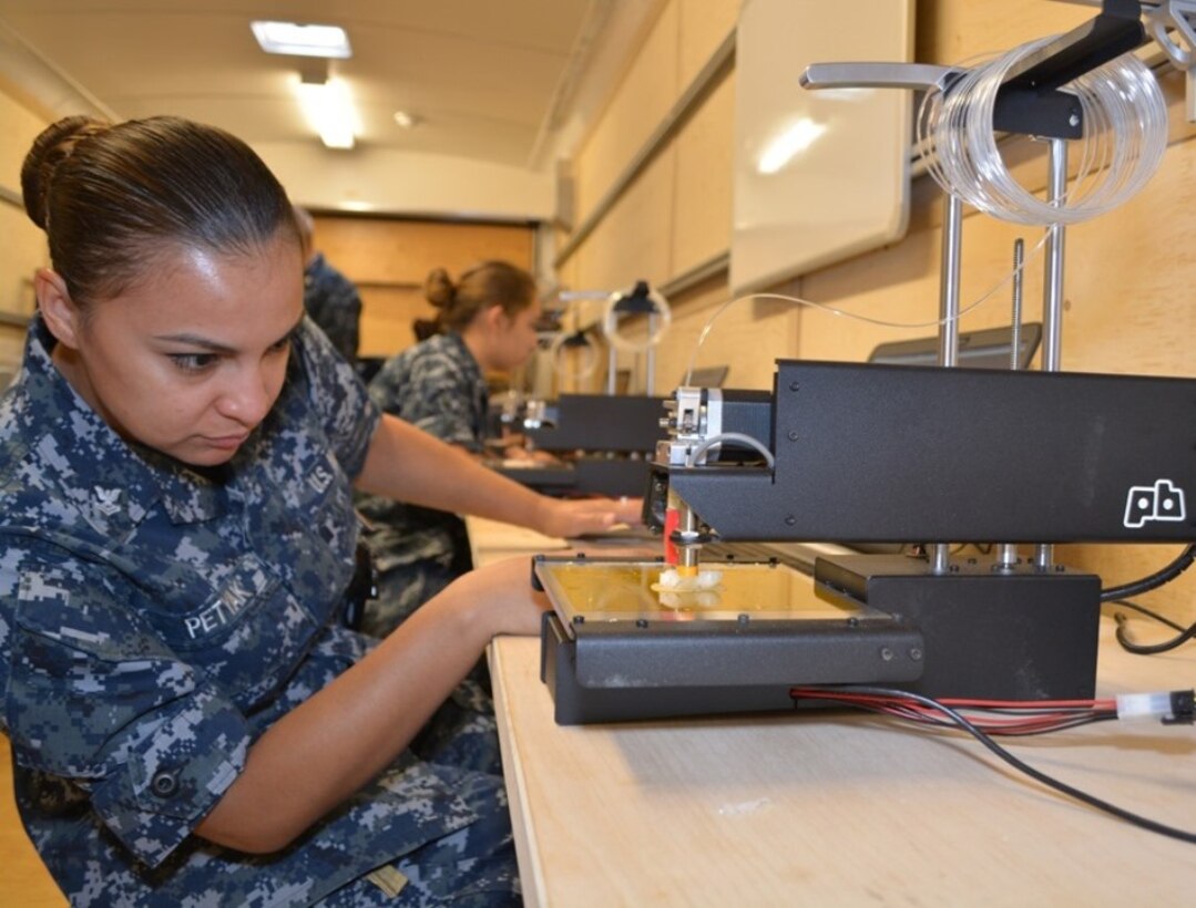 Machinery Repairman 2nd Class Lisa Petyak watches the 3-Dimensional (3-D) printer inside SERMC's Fabrication Laboratory, or Fab Lab. The Fab Lab hopes to spark creativity and problem-solving skills for Sailors assigned to SERMC.