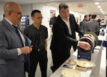 Dr. John Fiore (left), Technical Director for Naval Surface Warfare Center, Dahlgren Division, listens as Harry Whittaker (right), the team lead for NSWC Carderock Division's Sailor Performance Support Technology, and Kevin Lin, a member of Carderock's Disruptive Technology Lab, demonstrate prototypes created for the Big Area Additive Manufacturing (BAAM) Test Article of the Optionally Manned Technology Demonstrator (OMTD) during the 3D Print-a-Thon, an event hosted by the Navy at the Pentagon on March 15, 2017. (U.S. Navy photo by Kelley Stirling/Released)