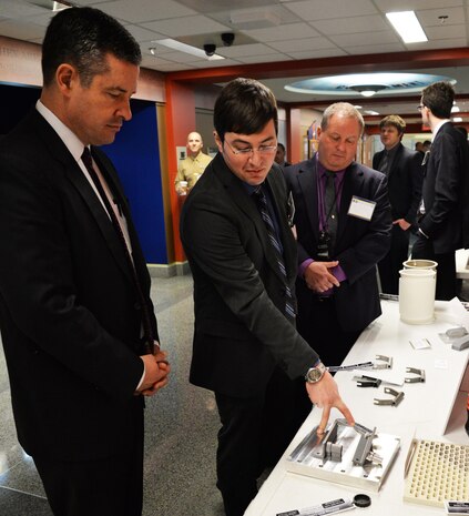 Michael Presley (center) and Craig Hughes (right), both from Johns Hopkins Applied Physics Lab (APL), highlights some details of the additive manufacturing process for U.S. Marine Corps Expeditionary hardware to Dale Ormond, principal director of research for the office of the Secretary of Defense, during the 3-D Print-a-thon hosted by the Navy at the Pentagon on March 15, 2017. (U.S. Navy photo by Kelley Stirling/Released)