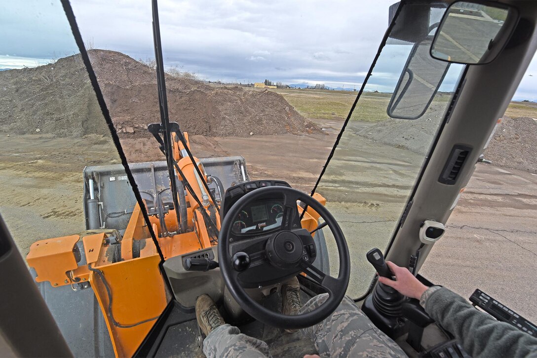 Airman 1st Class Manuel Rivera Matos, 92nd Civil Engineer Squadron pavement and construction journeyman, uses the loader to pick up dirt Mar. 15, 2017, at Fairchild Air Force Base, Washington. The 92nd CES pavement and construction Airmen and civilians are often referred to as “Dirt Boyz” for their constant interaction with more than 100 pieces of filthy heavy construction equipment and hand tools used to repair Fairchild’s roads, airfield, fences and drainage systems. (U.S. Air Force photo/Senior Airman Mackenzie Richardson) 