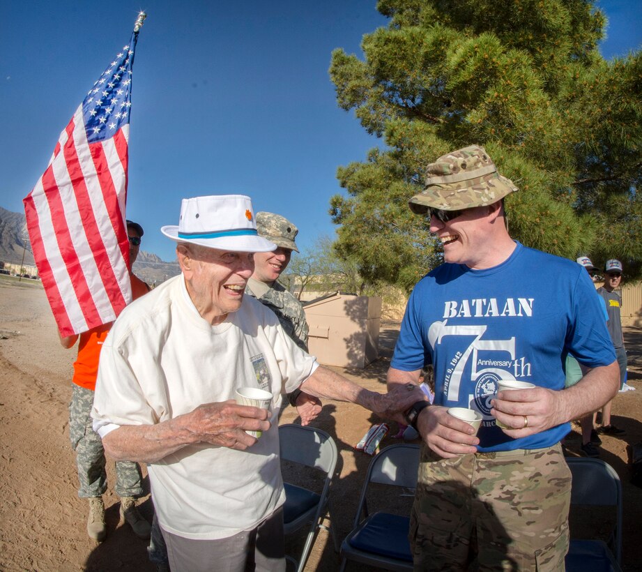 Retired Army Col. Ben Skardon, left, laughs with Army Master Sgt. Mike Lavigne, a volunteer at water station No. 1 during the Bataan Memorial Death March at White Sands Missile Range, N.M., March 19, 2017. Army photo by Staff Sgt. Ken Scar