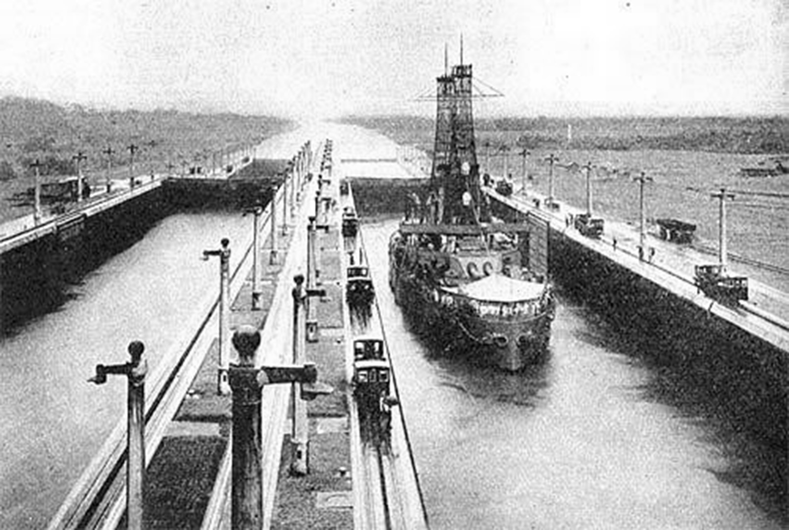 The USS Wisconsin proceeds through the Middle East Chamber Of Gatun Lock, Panama Canal, in July 1915. Electric locomotives haul the ships through the locks.