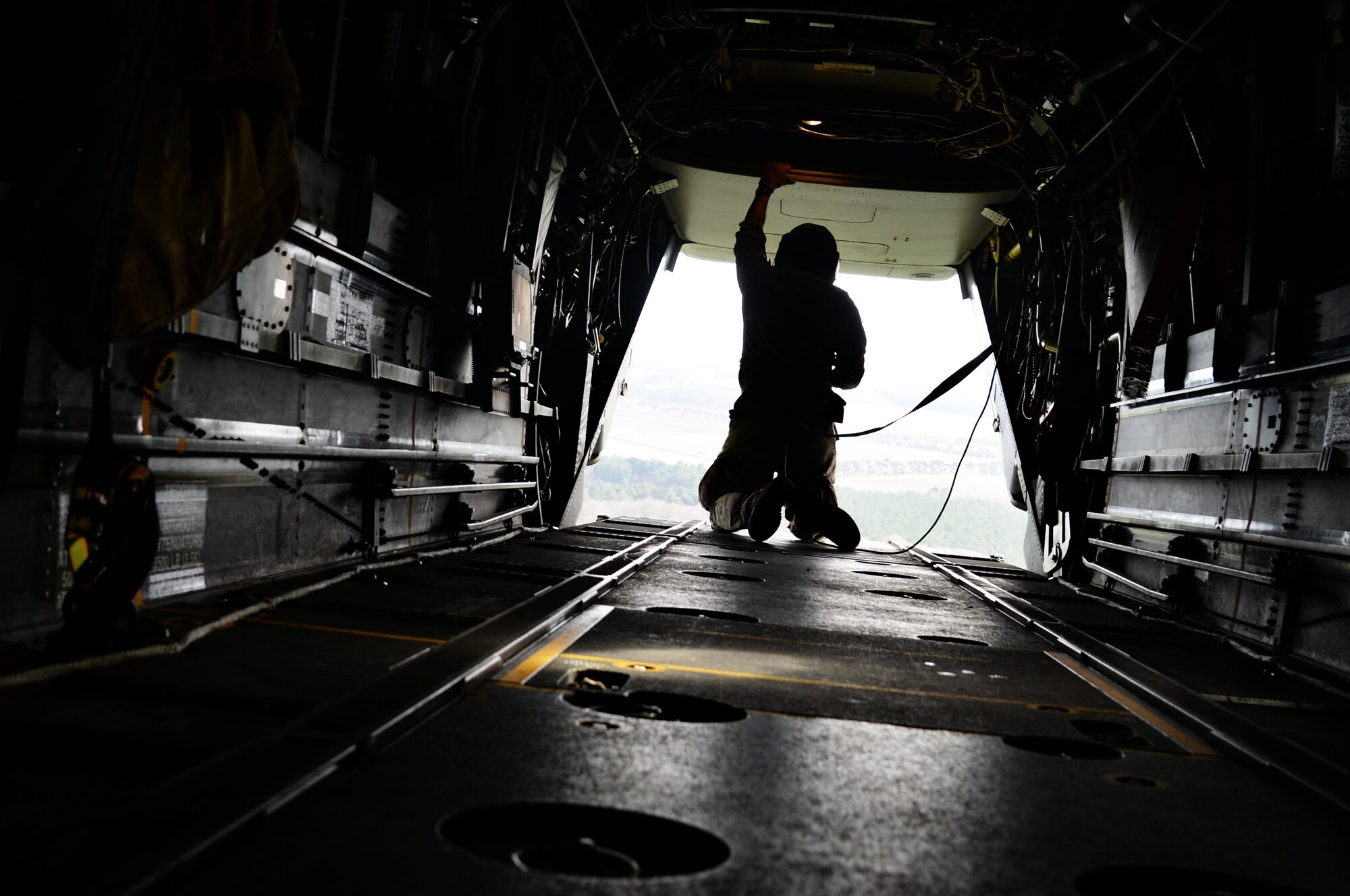 A flight engineer assigned to the 7th Special Operations Squadron opens the cargo ramp of a CV-22 Osprey assigned to the 7th Special Operations Squadron, March 17, 2017, over RAF Mildenhall, England. Once the aircraft neared the drop zone, members of the 321st Special Tactics Squadron prepared for a military free fall. The exercise allows flight crew and 321st STS Air Commandos to practice safely deploying from aircraft to reach designated drop zones. (U.S. Air Force photo by Senior Airman Justine Rho)