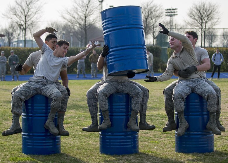 Airmen from the 606th Air Control Squadron participate in the barrels portion of the first Combat Warrior Challenge at Aviano Air Base, March 14, 2017. Each team was required to move four barrels 20 yards without participants touching the ground. (U.S. Air Force photo by Senior Airman Cory W. Bush)