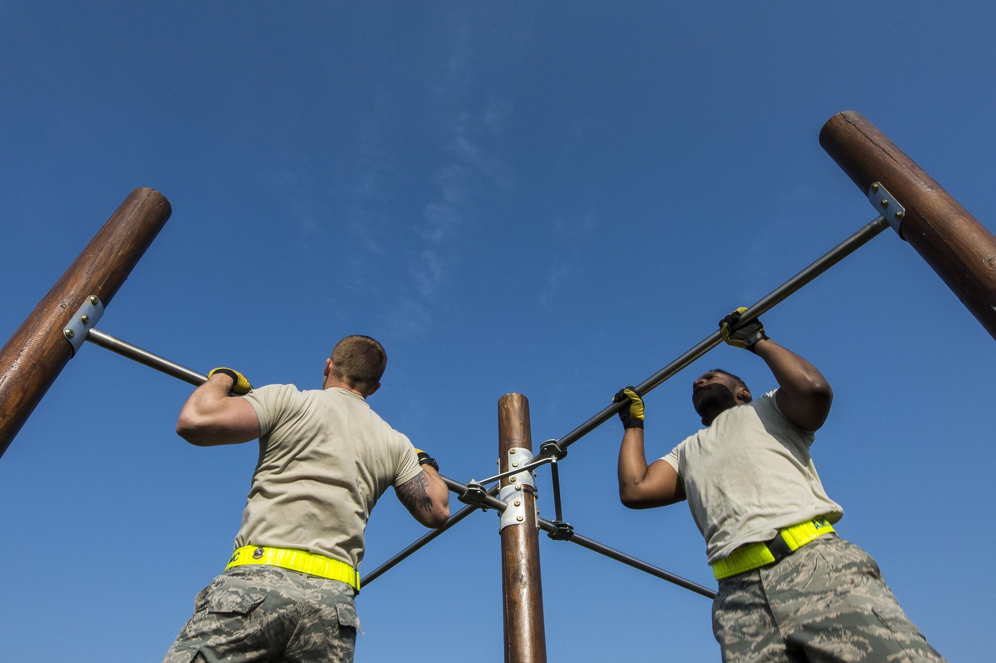 Airmen from the 724th Air Mobility Squadron perform pull-ups during the first Combat Warrior Challenge at Aviano Air Base, March 16, 2017. Each team had to perform a combined total of 50 pull-ups before moving on to the next obstacle. (U.S. Air Force photo by Senior Airman Cory W. Bush)