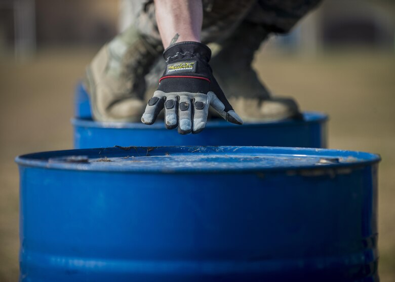 First Lt. Ryan Deming, 31st Munitions Squadron member, reaches for a barrel during the first Combat Warrior Challenge at Aviano Air Base, March 16, 2017. Each team had to move four barrels 20 yards without participants touching the ground. (U.S. Air Force photo by Senior Airman Cory W. Bush)