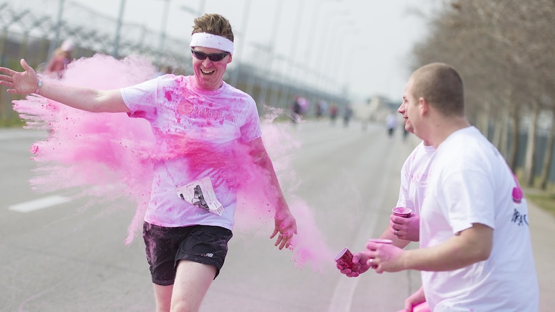 A Team Aviano member runs through pink powder during the 11th Annual Breast Cancer Awareness Walk at Aviano Air Base, Italy, March 18, 2017. The event had its largest turnout and money raised since its inception. (U.S. Air Force photo by Senior Airman Cory W. Bush)