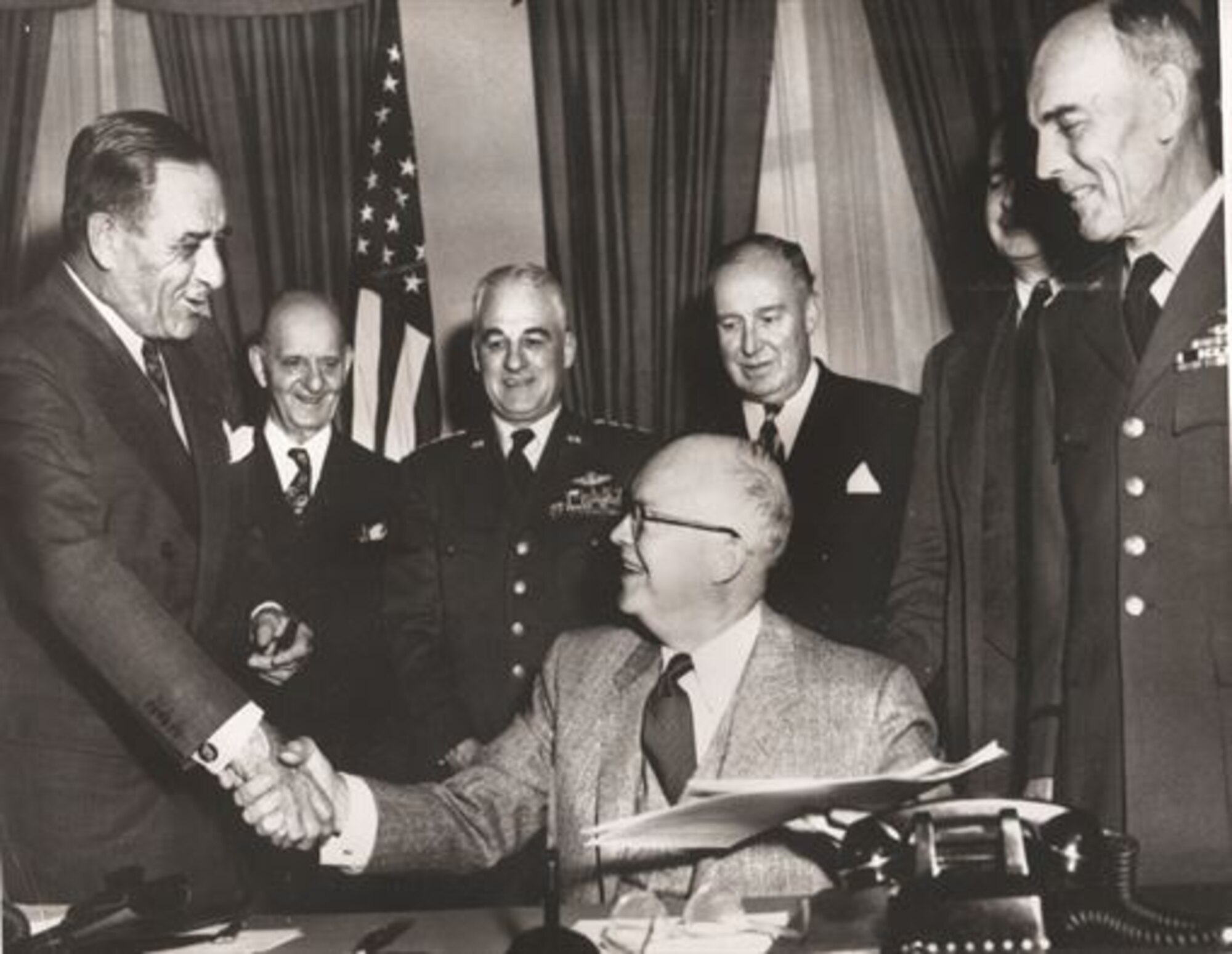 President Dwight Eisenhower (seated) shakes hands with Secretary of the Air Force Harold Talbott, April 1, 1954, after signing legislation authorizing the establishment of the U.S. Air Force Academy. Looking on (from left) are Congressman Karl Vinton, of Georgia; Gen. Nathan Twining, Air Force chief of staff; Congressman Dewey Short, chairman of the House Armed Services Committee; James Douglas, undersecretary of the Air Force, and Lt. Gen. Hubert Harmon, special assistant for the Academy. Harmon was the first superintendent of the U.S. Air Force Academy. (U.S. Air Force Academy)