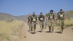Soldiers for Company D. 1-151 Infantry competing in the heavy division cross the mile 13 marker of the Bataan Memorial Death March. Pictured from left, Spc. Justin Stuart, Sgt. 1st Class Josh Chenault, Spc. Blade Cain, Spc. Adam Freese and Sgt. Ryan O’Donnell. 