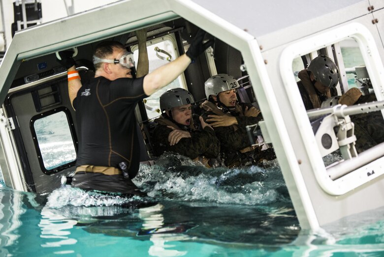 Marines with Special Purpose Marine Air-Ground Task Force - Southern Command assume brace positions as the Modular Amphibious Egress Trainer begins to submerge during Underwater Egress Training at the Water Survival Training Facility aboard Marine Corps Base Camp Lejeune, North Carolina, March 8, 2017. The purpose of the training is to teach Marines lifesaving skills in the event of an aircraft mishap in the water. (U.S. Marine Corps photo by Cpl. Melissa Martens/ Released)