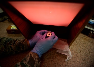 U.S. Air Force Senior Airman Ruben Mejia, 1st Maintenance Squadron precision measurement equipment laboratory technician, uses an optical flat and a chromatic light to quality check a gauge block at Joint Base Langley-Eustis, Va., March 17, 2017. Twenty-three Airmen and civilians work together each day to tackle the responsibility of calibrating approximately 5,100 pieces of equipment, ranging from torque wrenches, to equipment used to calibrate F-22 landing gear. (U.S. Air Force photo/Senior Airman Areca T. Bell)