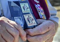 Retired U.S. Air Force Capt. William Robinson, longest surviving enlisted prisoner of war, holds a stamp, depicting him and a Vietnamese woman, used for propaganda after an award ceremony here, March 17, 2017. Robinson was a POW for nearly eight years before being released. Now, Robinson speaks about his experience with community and military members across the country.