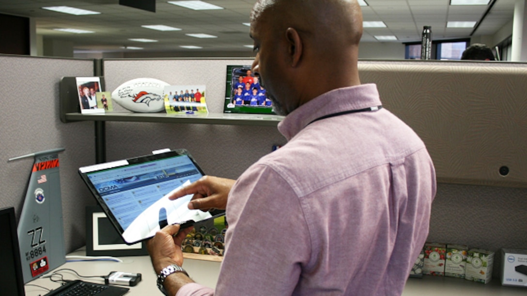 Mychael Bland, Defense Contract Management Agency Phoenix quality assurance specialist, uses a newly deployed 2-in-1 tablet computer to launch the agency’s eTools applications. (Photo courtesy of DCMA Phoenix)