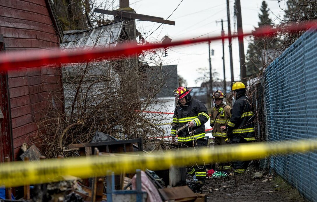 Firefighters sift through debris at a home in Medical Lake after a woman was found dead in the one-story structure that burned early Tuesday, March 14, 2017. Firefighters were called to the home near 703 E. Barker at 12:45 a.m., said Spokane County Sheriffs Deputy Mark Gregory. When they arrived on scene, firefighters saw large amounts of fire and smoke coming from the home. They were hampered by a large amount of clutter inside and out, Gregory said. While fighting the fire, they learned that a woman might still be inside, Gregory said. But firefighters were unable to enter the structure. Fire Departments from Medical Lake, Airway Heights, Spokane, Fairchild Air Force Base and Spokane County fire districts 3, 9 and 10 arrived at the scene. (Kathy Plonka / The Spokesman-Review)