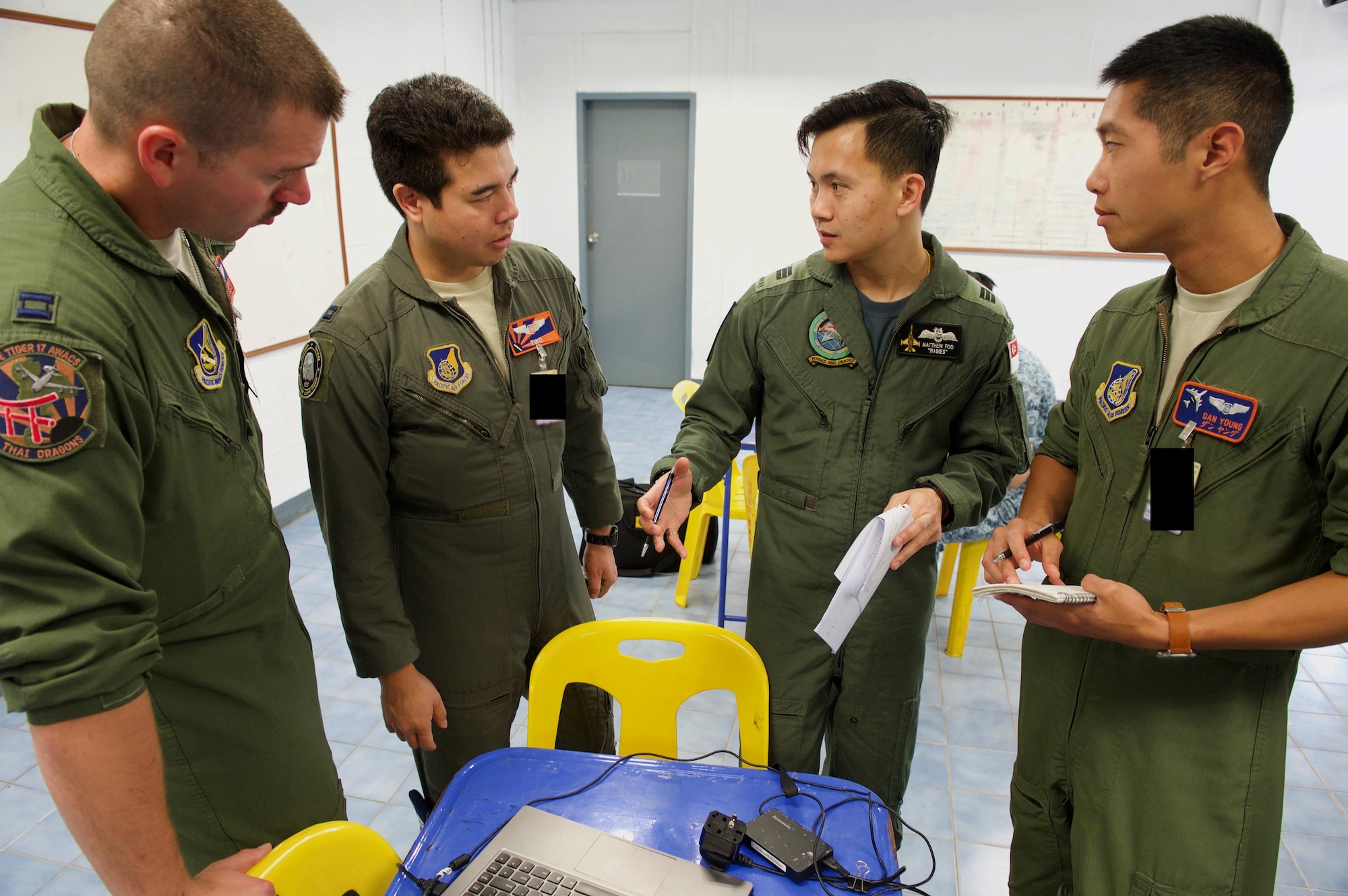 U.S. Air Force pilots with 961st Airborne Air Control Squadron from Kadena Air Base, Japan and a Republic of Singapore air force pilot discuss mission planning in preparation for a large formation exercise during exercise Cope Tiger 2017 at Korat Royal Thai Air Force Base, Thailand, March 21, 2017. Over 1,200 U.S., Thai and Singaporean military members will participate in CT17. The annual multilateral exercise is aimed at improving combined combat readiness and interoperability between the Republic of Singapore air force, Royal Thai air force, and U.S. Air Force, while concurrently enhancing the three nations' military relations. (U.S. Air Force photo by Staff Sgt. Kamaile Chan)