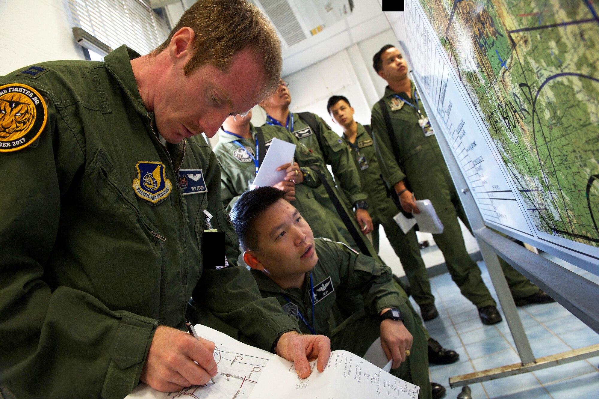 U.S. Air Force Capt. Clayton Cruickshank, F-15 pilot with the 44th Fighter Squadron from Kadena Air Base Japan, prepares for a large formation exercise with pilots from the Royal Thai air force and Republic of Singapore air force during exercise Cope Tiger 2017 at Korat Royal Thai Air Force Base, Thailand, March 21, 2017. Over 1,200 U.S., Thai and Singaporean military members will participate in CT17. The annual multilateral exercise is aimed at improving combined combat readiness and interoperability between the Republic of Singapore air force, Royal Thai air force, and U.S. Air Force, while concurrently enhancing the three nations' military relations. (U.S. Air Force photo by Staff Sgt. Kamaile Chan)