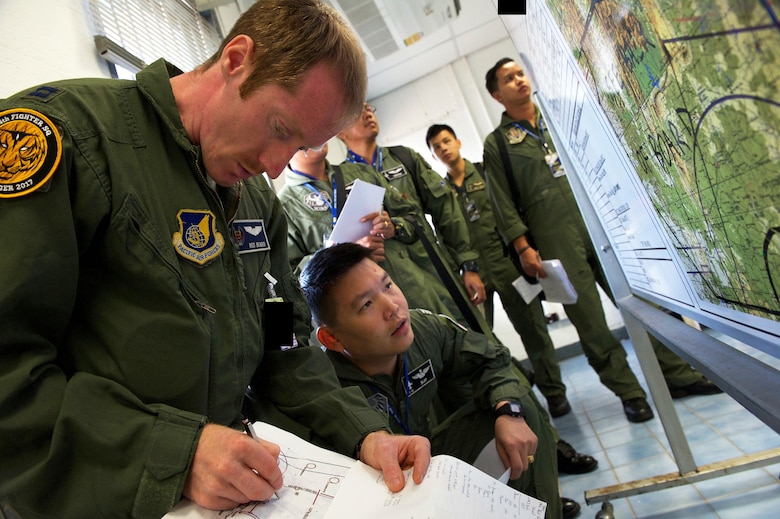U.S. Air Force Capt. Clayton Cruickshank, F-15 pilot with the 44th Fighter Squadron from Kadena Air Base Japan, prepares for a large formation exercise with pilots from the Royal Thai air force and Republic of Singapore air force during exercise Cope Tiger 2017 at Korat Royal Thai Air Force Base, Thailand, March 21, 2017. Over 1,200 U.S., Thai and Singaporean military members will participate in CT17. The annual multilateral exercise is aimed at improving combined combat readiness and interoperability between the Republic of Singapore air force, Royal Thai air force, and U.S. Air Force, while concurrently enhancing the three nations' military relations. (U.S. Air Force photo by Staff Sgt. Kamaile Chan)