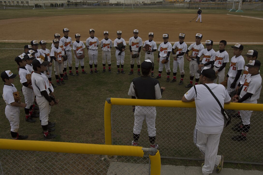 The Okinawa Diamond baseball team circles around their coach before a game against the Okiboys March 18 aboard Camp Foster, Okinawa, Japan. The Okiboys baseball team has been in existence for 12 years, and is an American high school level team that invites local teams like the Okinawa Diamond to come onto military bases and play. The Okinawa Diamond baseball team is from Naha, Okinawa, Japan.