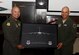 Col. Jimmy Canlas, left, 437th Airlift Wing commander, presents Brig. Gen. Brian Robinson, right, Headquarters Air Mobility Command director of operations, with a picture of a C-17 Globemaster during an Operations Call for pilots assigned to the 437th AW at Joint Base Charleston, South Carolina, March 21. Robinson toured various facilities and met with key leadership during his visit.