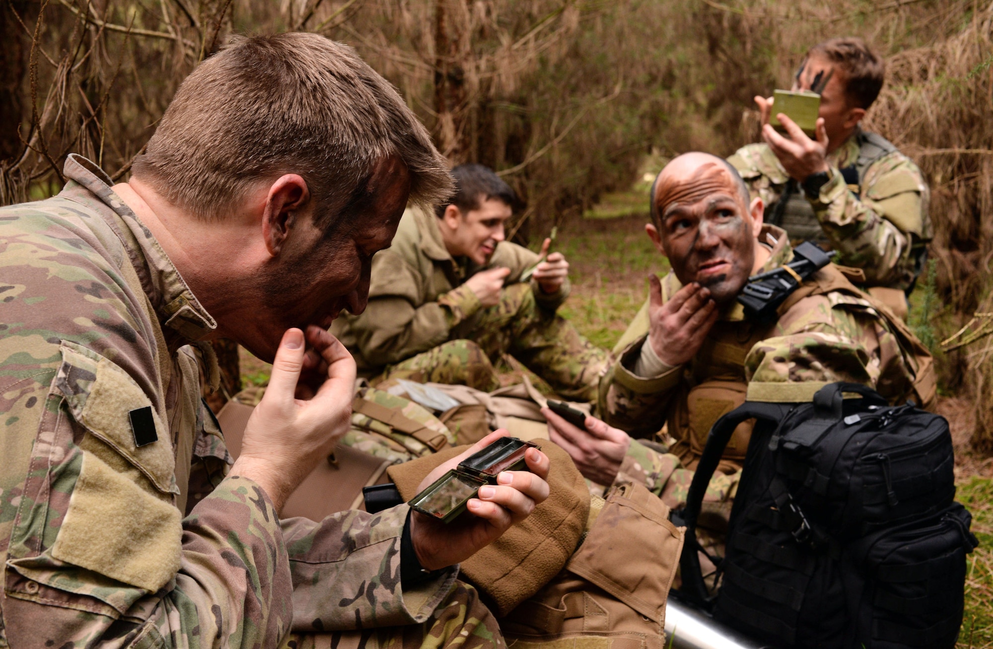 U.S. Air Force Airmen from the 352nd Special Operations Group apply camouflage paint to their faces March 8, 2017, at the Stanford Training Area, England. A Survival, Evasion, Resistance and Escape instructor trained Airmen how to properly apply face paint based on the environment. (U.S. Air Force photo by Senior Airman Christine Halan) 