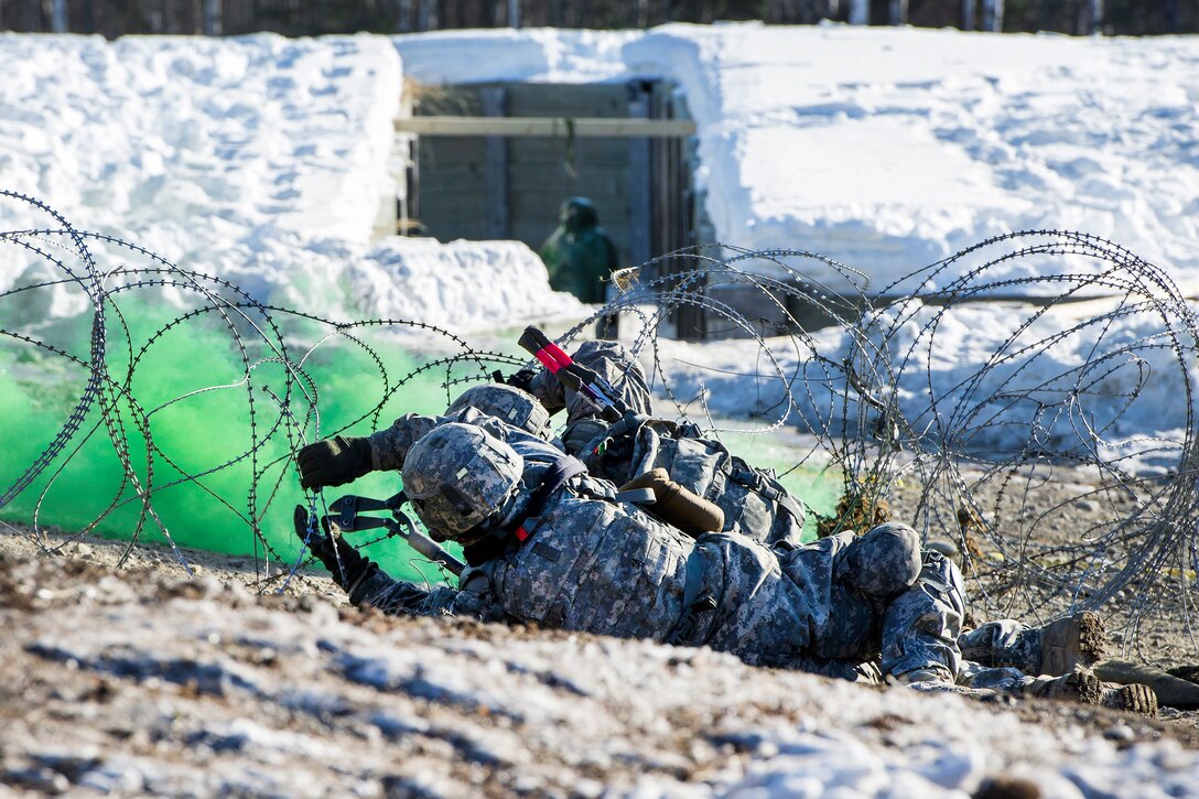 Soldiers cut concertina wire while breaching an obstacle during live-fire training at the Infantry Platoon Battle Course, Joint Base Elmendorf-Richardson, Alaska, March 17, 2017. Air Force photo by Alejandro Pena