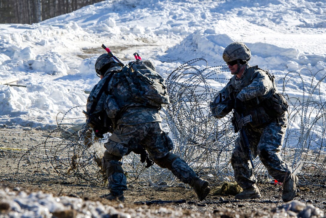 Army Pfc. Jose Zapata, left, and Staff Sgt. Ezekiel Farley, clear concertina wire while breaching an obstacle during live-fire training at the Infantry Platoon Battle Course, Joint Base Elmendorf-Richardson, Alaska, March 17, 2017. Zapata and Farley are assigned to the 25th Infantry Division’s Company A, 6th Brigade Engineer Battalion, 4th Infantry Brigade Combat Team (Airborne). Air Force photo by Alejandro Pena