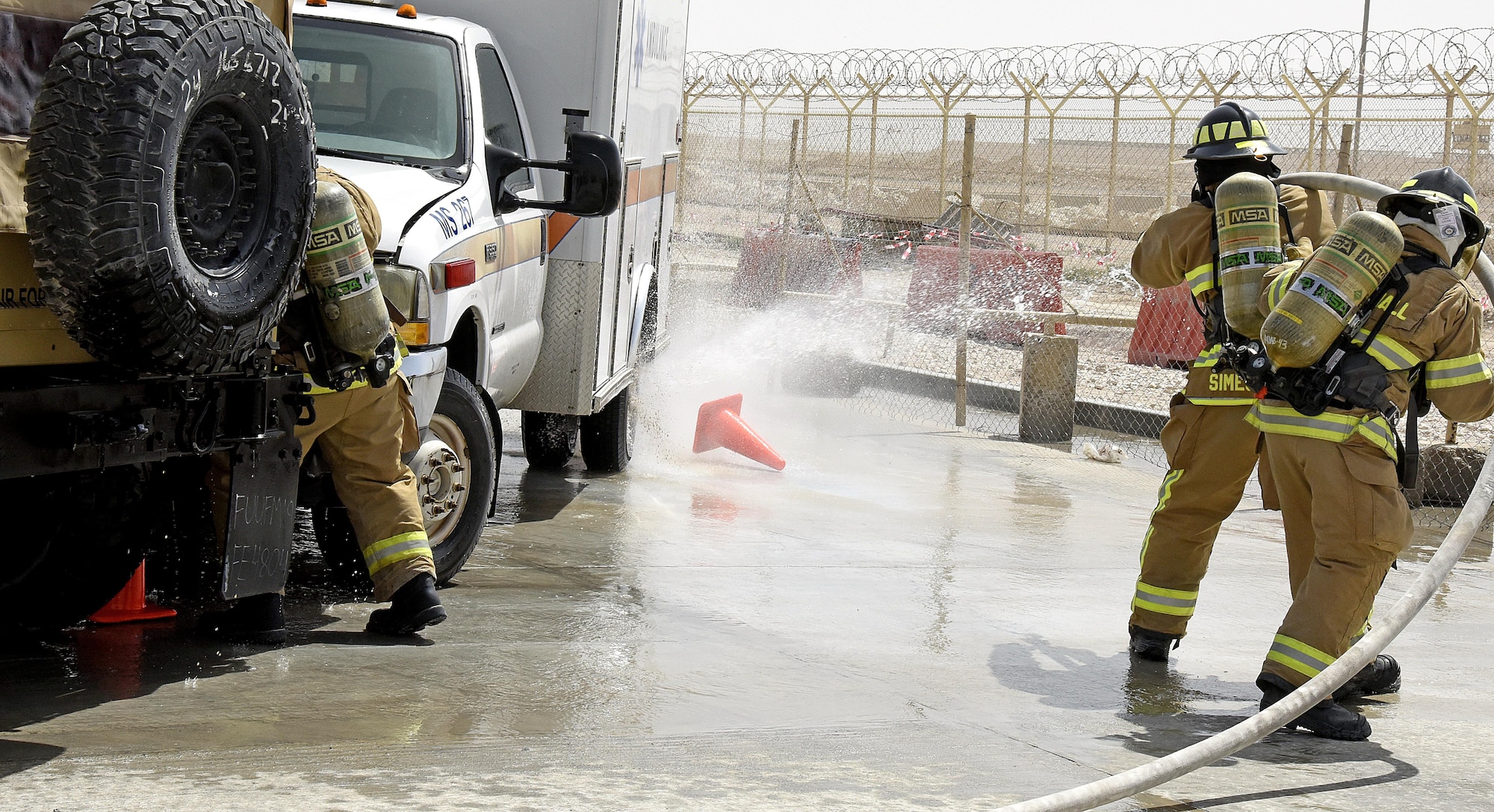 U.S. Air Force firefighters with the 379th Expeditionary Civil Engineer Squadron spray simulated points of fire during a Lifeflight medical trauma exercise at Al Udeid Air Base, Qatar, March 21, 2017. During the exercise, firefighters put out a simulated fire resulting from a mock vehicle accident. Scenarios like these are enacted to help first responders train and maintain their skillsets. (U.S. Air Force photo by Senior Airman Cynthia A. Innocenti)