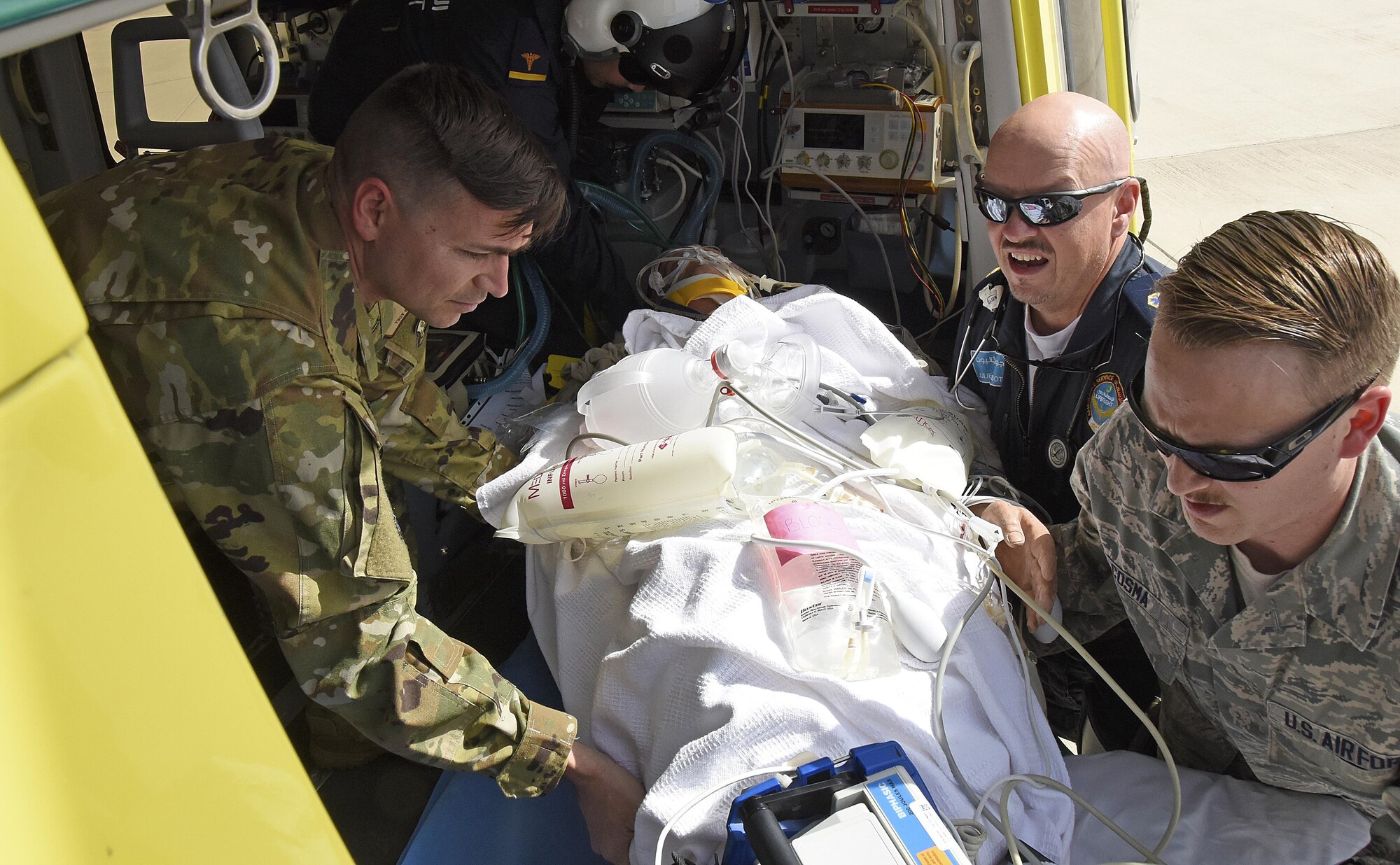 U.S. Air Force and civilian medical professionals lift a practice model into a Lifeflight aircraft at Al Udeid Air Base, Qatar, March 21, 2017. Base personnel exercised their skillsets during a Lifeflight medical trauma training exercise, extracting a mock patient from a vehicle accident to transport them to the flightline for medical evacuation. (U.S. Air Force photo by Senior Airman Cynthia A. Innocenti)