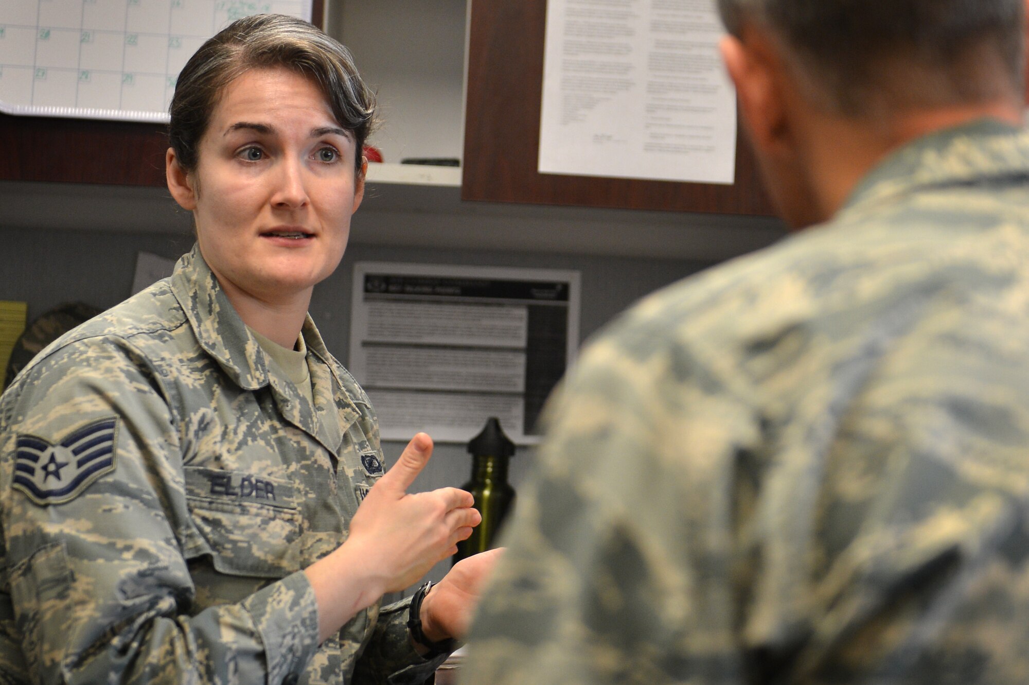 U.S. Air Force Staff Sgt. Molly Elder, 20th Fighter Wing (FW) Public Affairs (PA) broadcast journalist craftsman, speaks with an Airman about a project at Shaw Air Force Base, S.C., March 21, 2017. Before any product, written, photographic or video is posted to Shaw’s official communication outlets it must undergo extensive review for accuracy, brevity, operational security and critical information. (U.S. Air Force photo by Airman 1st Class Christopher Maldonado)