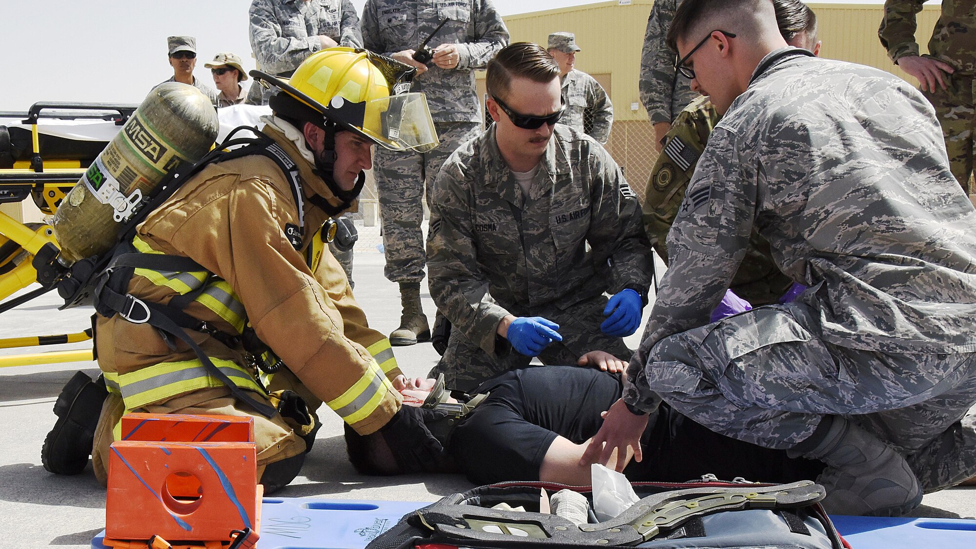 U.S. Air Force Airmen with the 379th Expeditionary Medical Group and firefighters with the 379th Expeditionary Civil Engineer Squadron lift a role player acting as a trauma patient at Al Udeid Air Base, Qatar, March 21, 2017. Scenarios like these are enacted to help first responders train and maintain their skillsets. (U.S. Air Force photo by Senior Airman Cynthia A. Innocenti)