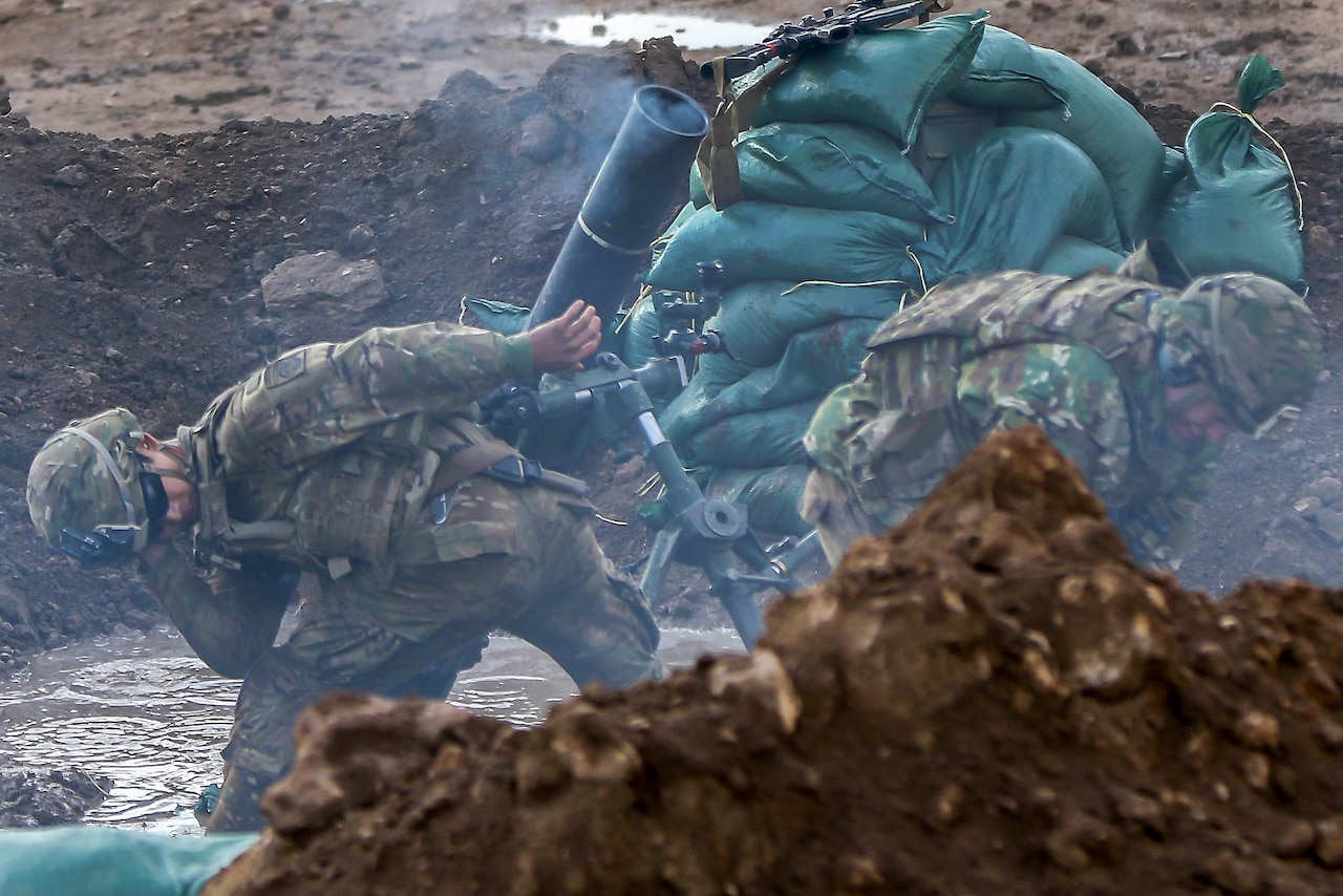 Soldiers brace themselves while firing mortar rounds during a fire mission supporting the Iraqi army's 9th Division near Tarab, Iraq, March 14, 2017. Army photo by Sgt. Thomas Carwell