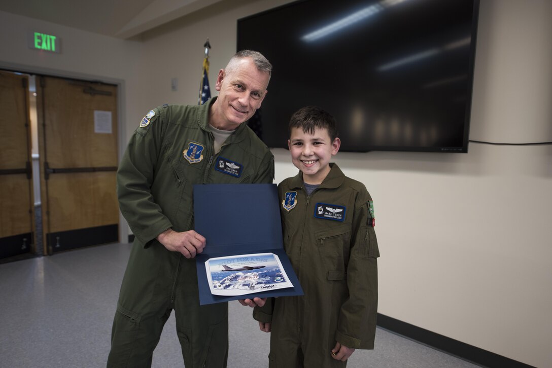 Col. Daniel Swain, 141st Air Refueling Wing commander, presents "Pilot for a Day" candidate Gabe Tesch with his pilot completion certificate March 1, 2017, at Fairchild Air Force Base, Wash. Gabe spent the day visiting several workcenters throughout the base receiving hands on instruction and briefings on what it takes to be a KC-135 pilot. The "Pilot for a Day" program provides disadvantaged or seriously ill children a chance to spend the day with members of the Washington Air National Guard training as an honorary pilot. (U.S. Air Force photo by Master Sgt. Michael Stewart/Released)
