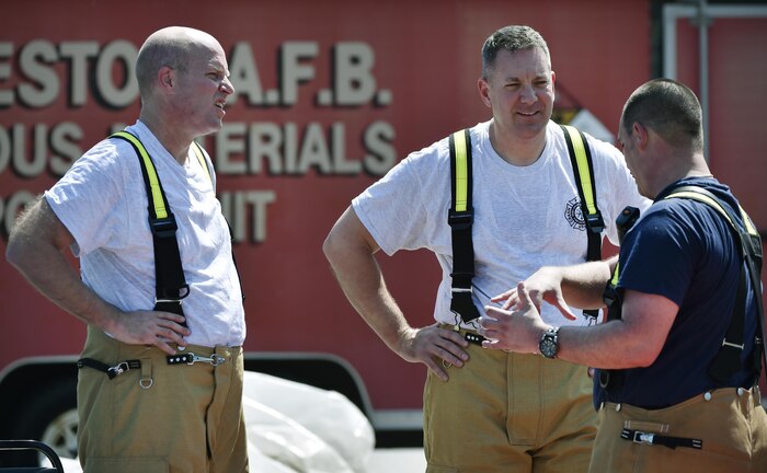 Col. Robert Lyman, center, 628th Air Base Wing commander, and Chief Master Sgt. Todd Cole,  left, 628th ABW command chief, talk to Glen Pilger, right, 628th Civil Engineer Squadron firefighter, during a live-fire training exercise at Joint Base Charleston, South Carolina, March 21, 2017. Lyman and Cole worked alongside 628th CES firefighters to fight a controlled aircraft fire during the training. The training participants practiced fighting fires on an Aircraft Training Fire Mock Up to become current on mobility and annual training requirements. 