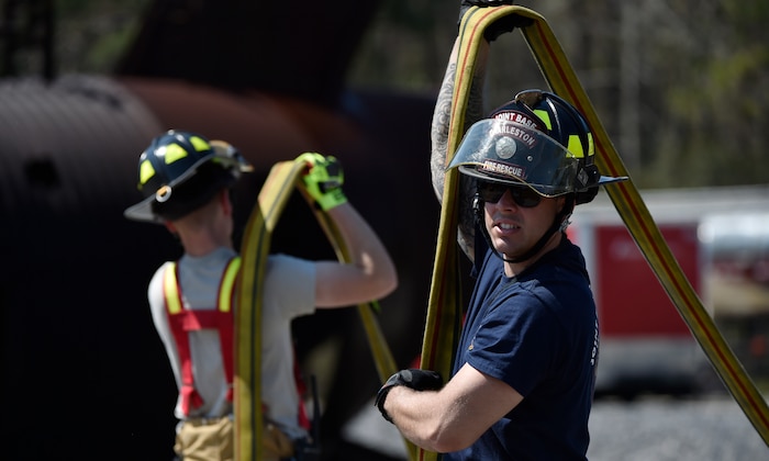 Jonathen Relkin, 628th Civil Engineer Squadron firefighter, prepares fire hoses for a live-fire exercise at Joint Base Charleston, South Carolina, March 21. The training participants practiced fighting fires on an Aircraft Training Fire Mock Up to become current on mobility and annual training requirements. 