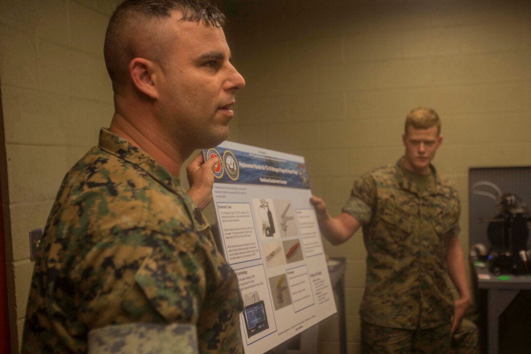 Marines hold a diagram explaining the capabilities they have with current 3-D printing technology at the additive manufacturing facility at Camp Lejeune, N.C., March 22, 2017. Nine members with the Defense Advanced Research Projects Agency visited the facility to learn more about how technology is benefitting the Marine Corps. The Marines are with 2nd Maintenance Battalion, Combat Logistics Regiment 25, 2nd Marine Logistics Group. (U.S. Marine Corps photo by Pfc. Abrey Liggins)